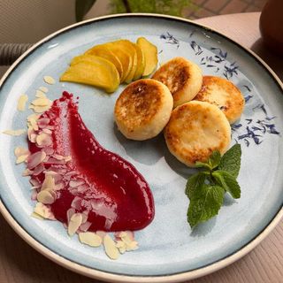 Сирники з малиновим соусом та карамелізованим яблуком