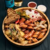 Тарілка ковбасок 4 види з картоплею, соусами та соліннями