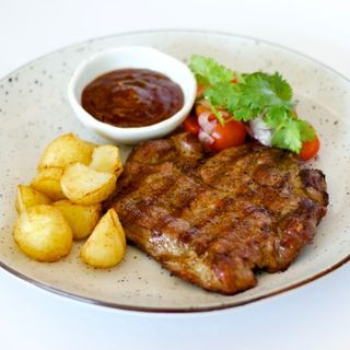 Стейк зі свинячої шиї з двома гарнірами та кисло-солодким соусом