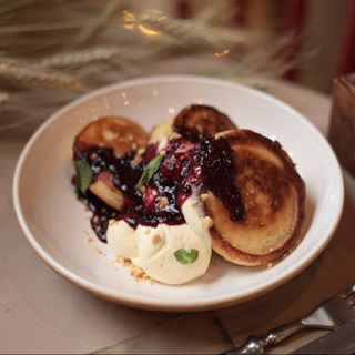 Пухкі оладки з ніжним вершковим кремом і джемом із чорної смородини