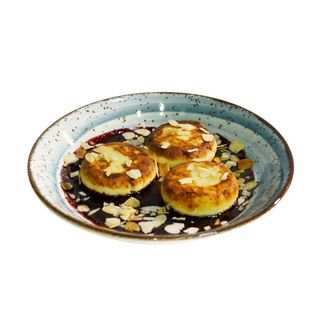 Сирники у ягідному соусі та з мигдалевими пластівцями