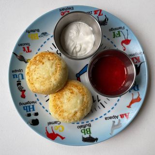 Сирники зі сметаною та полуничним соусом