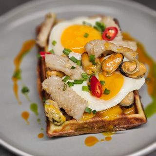 Оката яєчня на картопляній вафлі зі смаженим кальмаром та м'ясом мідій