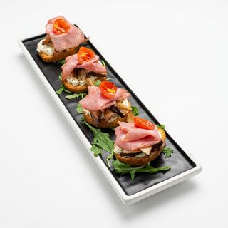 Crostino, pastrami, formaggio alle erbe, funghi cardoncelli e pomodori confit 4 pezzi