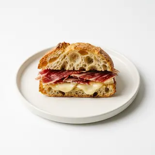 Jamón ibérico con queso tetilla en pan cristalino