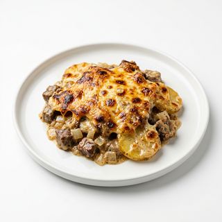 Plato Gratinado De Carne, Patatas Y Salsa De Queso