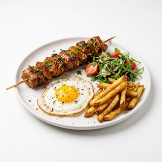 Pincho tipo moruno, patatas fritas, huevo a la plancha y ensalada