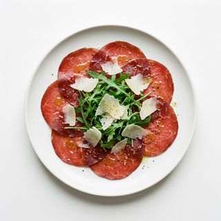 Carpaccio de bresaola sobre ensalada de rúcula