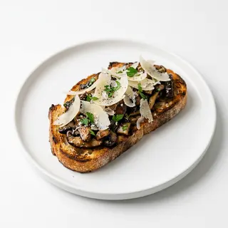 Bruschetta de setas salteadas con lascas de parmesano