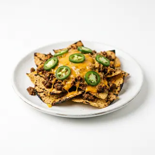 Nachos a la brasa con carne picada, jalapeños y queso cheddar