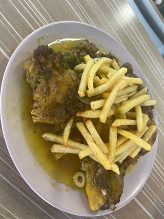 Tajin de pollo con patatas fritas y aceitunas acompañado con pan 