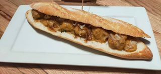 Bocadillo De Albóndigas Con Patatas Paja Y Cebolla Frita