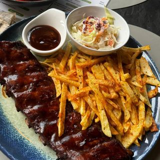 Coaste de porc, sos BBQ afumat cu cartofi prajiti și salată coleslaw