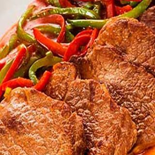 Bife de novilho com cebola e pimentos.