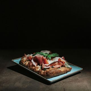 Pinsa, mozzarella, rucola, prosciutto crudo, grana, pachino