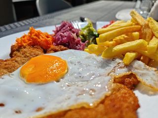 Sznycel po wiedeńsku z jajem sadzonym, frytkami i miksem surówek