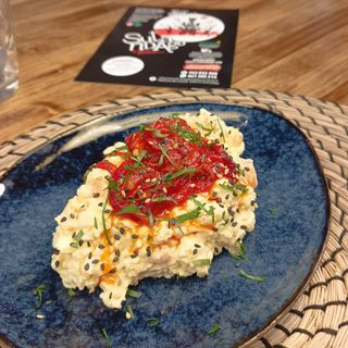 Ensaladilla Sutandera vegetariana con piquillos confitados y cebolla crispy