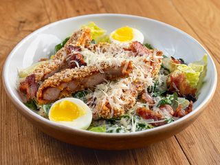 Салат Цезар з хрумкою куркою, м'яким яйцем та чіпсами з бекону (300г)