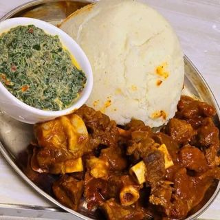 White ugali served with beef in Nigerian sauce and creamy spinach 
