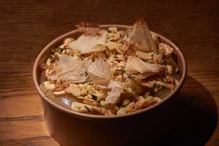 Cebollas asadas y aliñadas con tamarindo, cremoso de dashi, furikake y cebolleta china