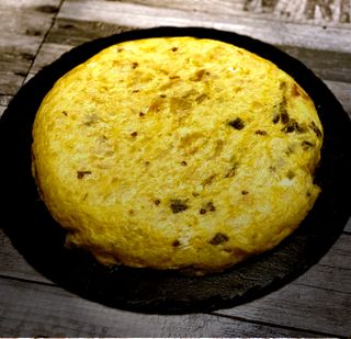 Tortilla de patata, pimiento italiano verde frito y cebolla