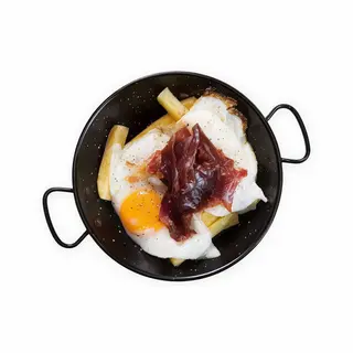 Sartén de huevos con jamón sobre cama de patatas