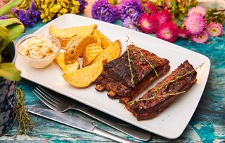 Coaste de porc cu cartofi wedges, salata coleslaw si sos barbeque