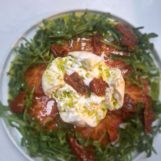 Burrata con tomates rúcula y pesto