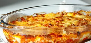 Berenjenas parmesano gratinado con mozarella, cheddar y bacon.