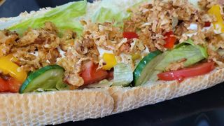 Hot dog z warzywami, cebulą prażoną i serem mozzarella