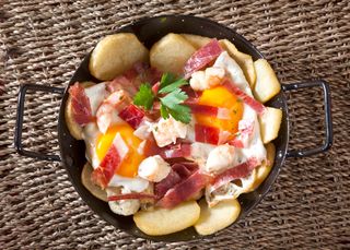 Huevos rotos con gambas y jamón