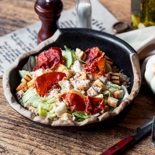 Caesar Deluxe: Salata iceberg, Dressing caesar, piept de pui, crutoane, sos de maioneza, prosciutto crudo