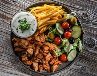 Gyros de Porc servit cu legume si cartofi prajiti cu sos tzaziky
