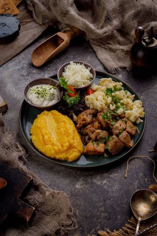 Tocană de porc cu mămăligă, smântână și brânză de oi