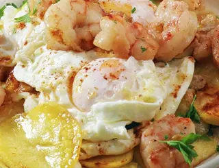 Huevos rotos con langostinos