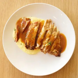 Secreto ibérico confitado a la naranja servido con parmentier de pata roja