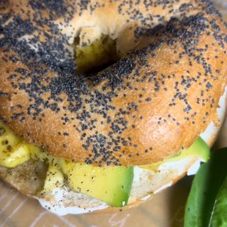 Avocado bagel servito con rucola e salsa allo yogurt
