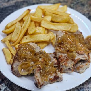 Secreto de cerdo con cebolla caramelizada acompañado con papas fritas 