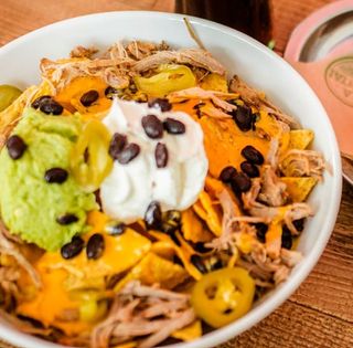 Nachos con salsa picante, cheddar y guacamole