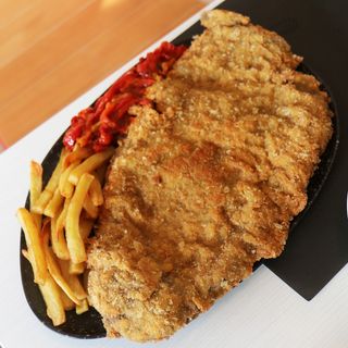 Cachopo de ternera con patatas y pimientos