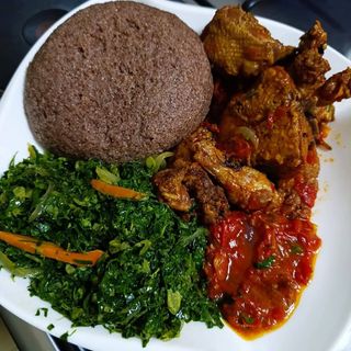 Brown ugali served with chicken in Nigerian spicy sauce and sukuma