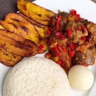 White rice, plantains peppered goatmeat and boiled egg