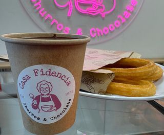 Un vaso de chocolate y 3 churros lazo