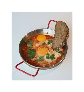 Шакшука на сковороде с овощами и хрустящим хлебом 