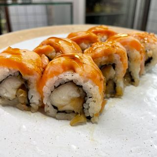 Uramaki de anguila ahumada, cebolla caramelizada y salmón flameado