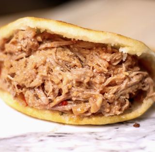 Arepa Venezolana Pelua (carne mechada y queso amarillo rallado)