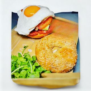 Uovo bagel servito con rucola e salsa senape e miele