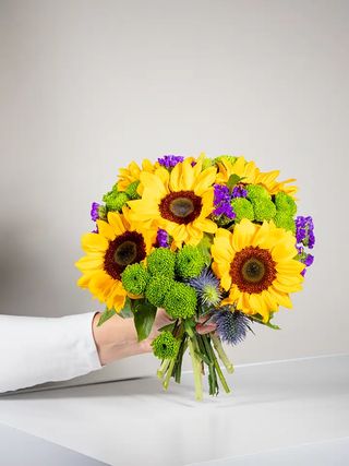 Bouquet di girasoli e fiori viola