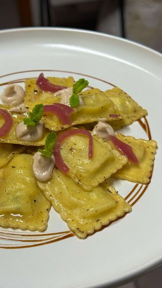 Ravioli di pasta fresca ripieni, gocce di salsa tonnata, cipollotto dolce e polvere di olive nere