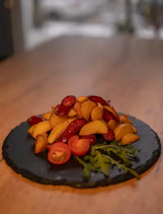 Картопля запечена з ковбасками та беконом, руколою та томатом (300г)